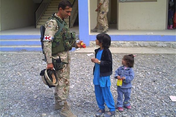 Наш медик разговаря с дете на улицата в Афганистан по време на мисия в размирната страна. 

