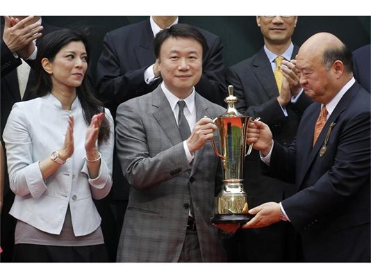 Стиван Ло получава трофей от конни надбягвания на пистата в Хонконг. До него е съпругата му. 
СНИМКА: РОЙТЕРС
