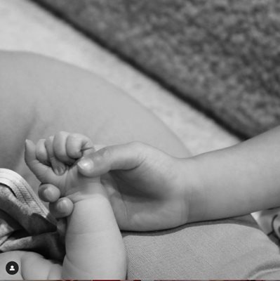 Кайли Дженър публикува в инстаграм черно-бяла снимка на бебешка ръчичка, датата е 2/2/22.