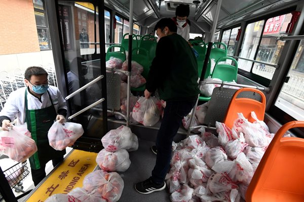 Служители на супермаркет товарят пакети с храна, които да бъдат изпратени в кварталите под карантина в Ухан - епицентър на заразата в Китай.