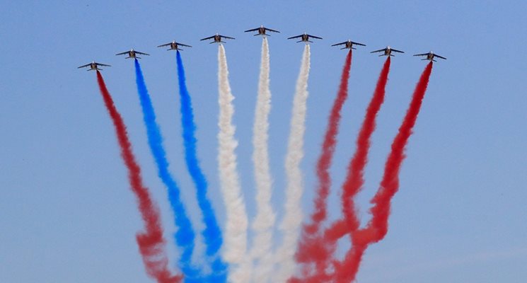 Един от самолетите "Алфаджет", украсили небето над Париж с цветовете на националното знаме, пуска червен пушек вместо син. Снимка РОЙТЕРС