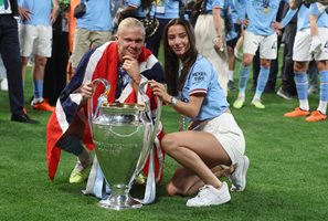 Ерлинг Браут Холанд с приятелката си Изабел и трофея от Шампионската лига. Снимка: Ройтерс