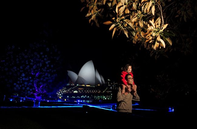 Баща наблюдава с дъщеричката си фестивала на светлините от операта в Сидни.