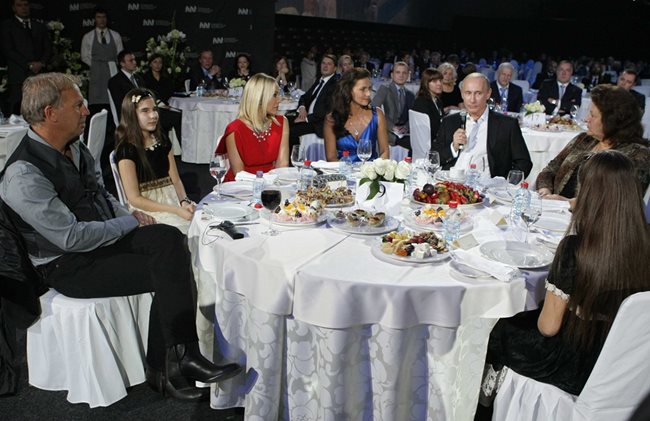 Орнела Мути (в червено) на благотворителна вечеря с Путин и Кевин Костнър (вляво)