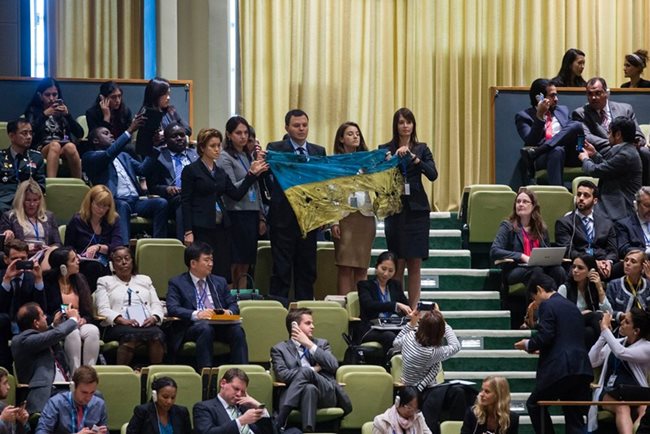 Юлия и колегите й развяват надупченото от куршуми знаме на Украйна по време на речта на Путин в ООН.