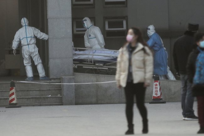 Медици карат на носилка пациент с пневмония в китайския град Ухан, откъдето тръгна заразата.
