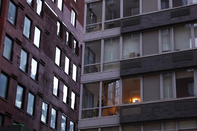 Жена отваря прозореца на апартамента си, за да аплодира медицински работници по време на огнището на коронавирусна болест (COVID-19) в Манхатън, Ню Йорк. Снимка: Ройтерс