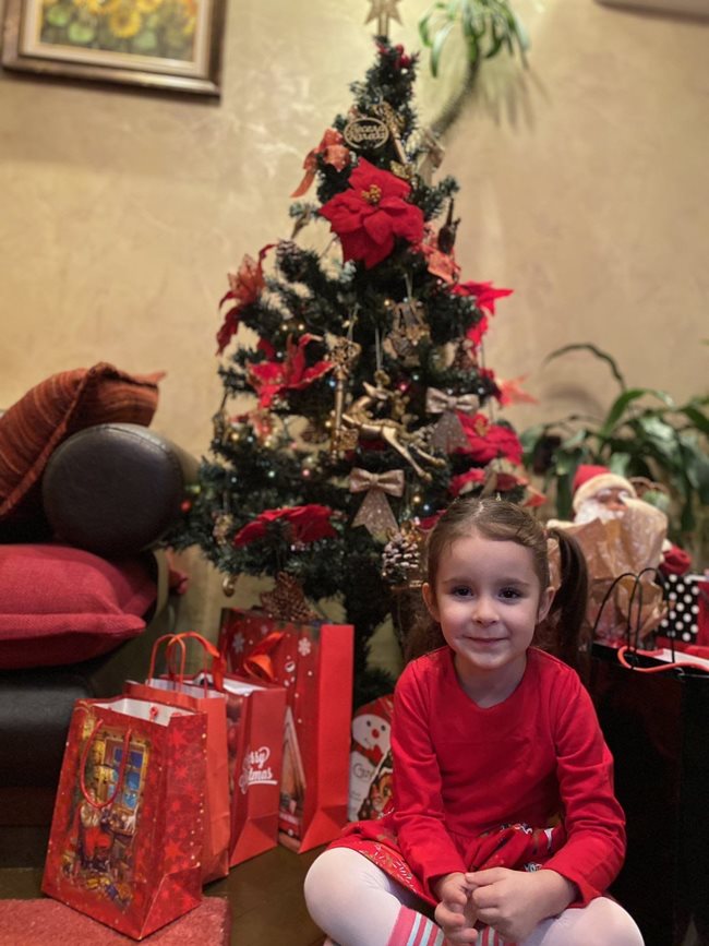 От съвсем мъничка хубавата Сияна от Ботевград участва в традиционния фотоконкурс на “24 часа” “Дете под елхата”. Сега, 4-годишна, тя позира кротко и както винаги усмихната пред  украсеното коледно дръвче вкъщи.