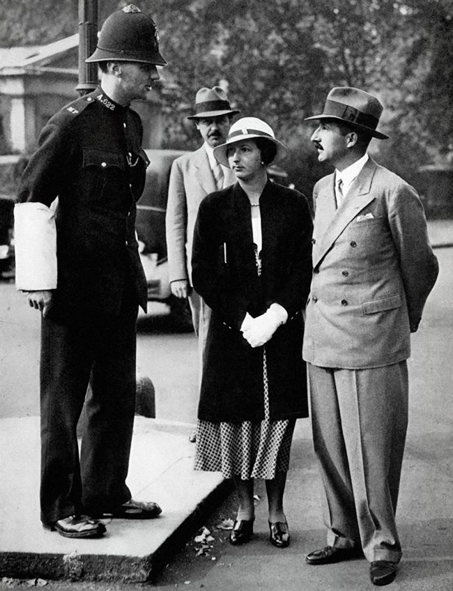 Царят и царицата разговарят с лондонски полицай. Отзад е дворцовият хронист Георги Ханджиев.