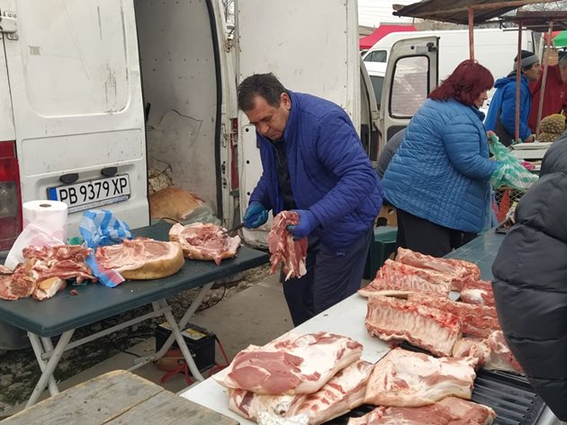 Мъжът разфасова прасето, а жена му на кантара тегли и продава на пазара в Секирово.