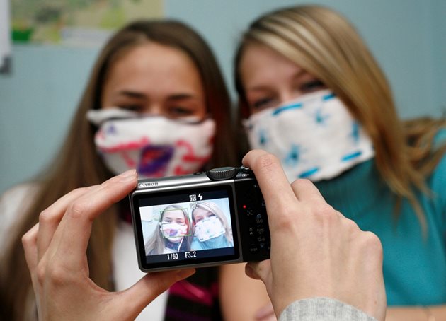 Момичета се снимат с маски в пика на епидемията.