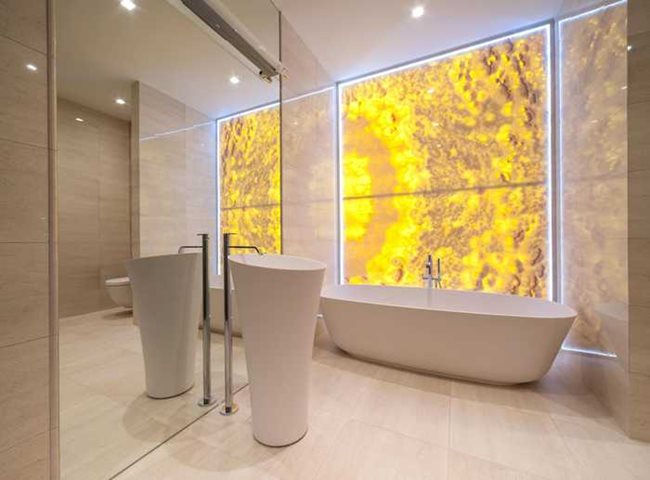 Стената от светещ оникс в банята е един от най-ефектните елементи в жилището Снимки pufikhomes.com