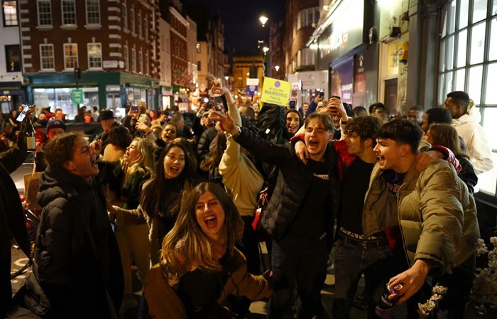 Десетки млади хора се забавляват в последните часове преди общественият живот в Лондон да бъде блокиран. Тълпи се събраха по търговските улици и пред баровете и ресторантите в британската столица. От сряда в полунощ заведенията няма да работят.