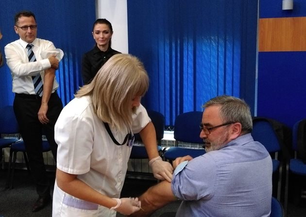 Главният държавен здравен инспектор д-р Ангел Кунчев се ваксинира срещу грип след дискусия за профилактиката, вляво изчаква реда си ръководителят на офиса на Световната здравна организация за България д-р Скендер Сила.