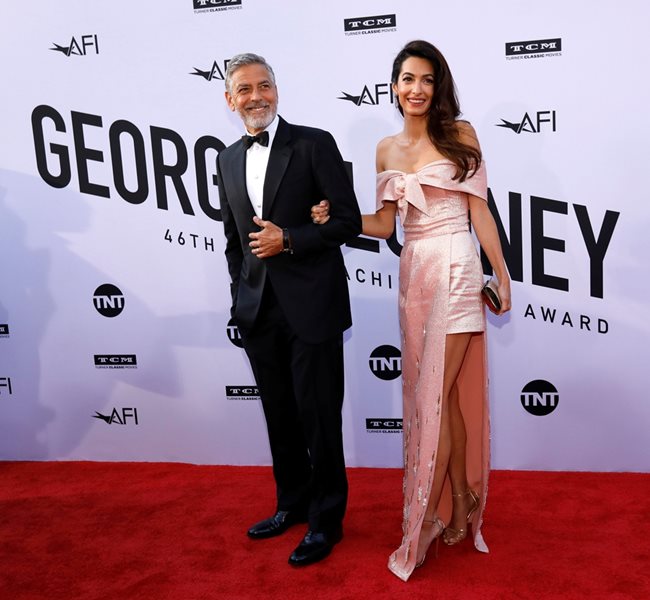 Джордж и Амал Клуни минават по червения килим на церемонията, на която той получи наградата за цялостен принос.