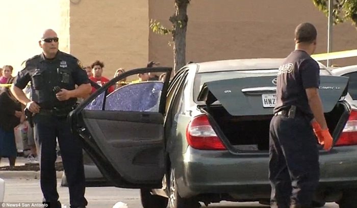 Полицай стои до колата на мъж, застрелян от побойник на паркинг в Тексас.