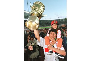 Красимир Балъков е качил на рамене дъщеря си Глория (бъдещата майка на внука му Диего Армандо), а в дясната ръка държи трофея за победител в турнира за купата на Германия, с която "Щутгарт" триумфира през 1997 г.

СНИМКА: РОЙТЕРС