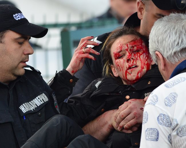 Колеги оказват помощ на полицайка, ранена от бомбичка на мач “Левски” - ЦСКА на 17 април тази година.   СНИМКА: ЙОРДАН СИМЕОНОВ