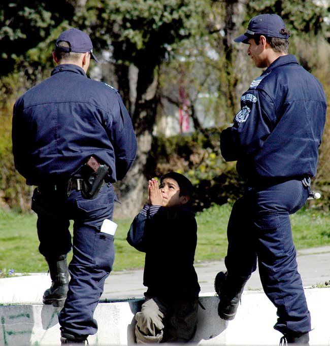 Дете от ромски произход се моли на полицаи да го пуснат, след като е заловено да проси в градинката пред НДК.   СНИМКА: ДЕСИСЛАВА КУЛЕЛИЕВА