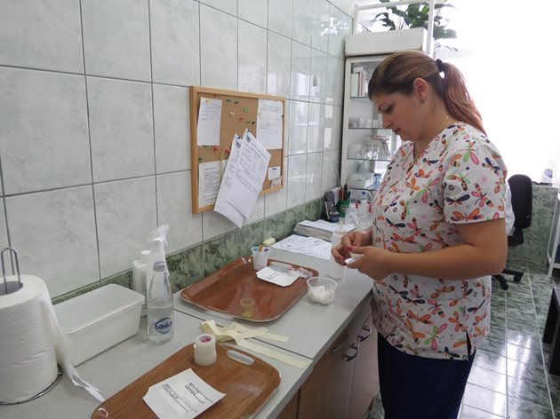 Старшата медицинска сестра Марина Савова подготвя консумативи и медикаменти за терапията на пациентите.