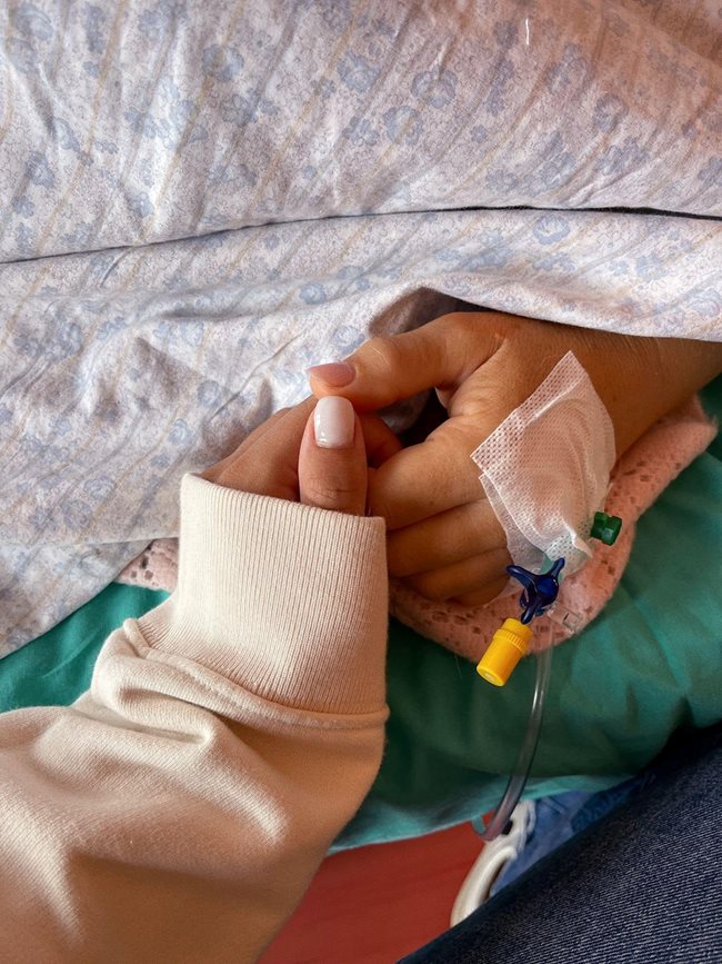 Кадър от болничната стая, в който Лори държи ръката на майка си